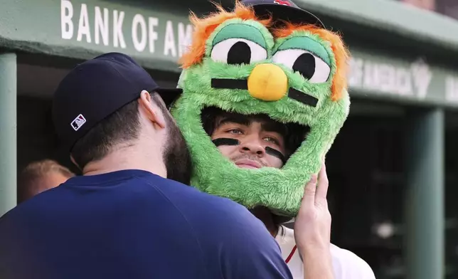 Boston Red Sox's Marcelo Mayer, right, is kissed on the Wally the Green Monster mask by pitcher Lucas Giolito (54) after his solo home run during the second inning of a baseball game against the Tampa Bay Rays at Fenway Park, Wednesday, June 11, 2025, in Boston. (AP Photo/Charles Krupa)