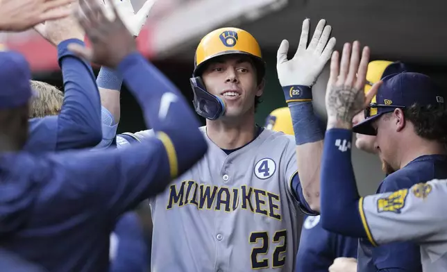 Milwaukee Brewers' Christian Yelich (22) celebrates with teammates after hitting a solo home run during the third inning of a baseball game against the Cincinnati Reds, Monday, June 2, 2025, in Cincinnati. (AP Photo/Jeff Dean)