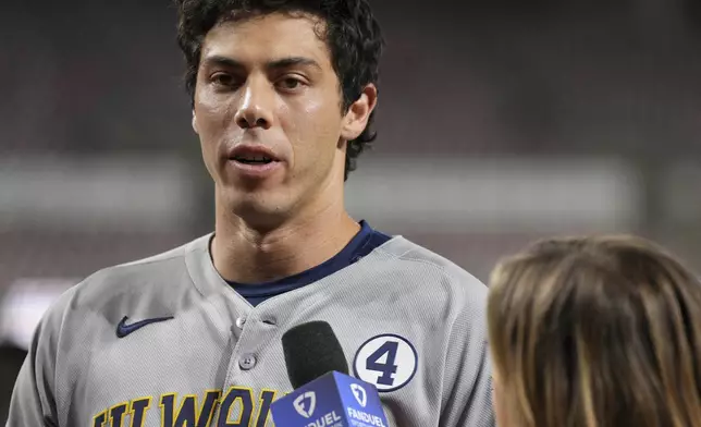 Milwaukee Brewers' Christian Yelich, left, is interviewed following a baseball game against the Cincinnati Reds, Monday, June 2, 2025, in Cincinnati. (AP Photo/Jeff Dean)