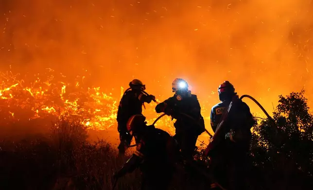 Firefighters battle with a large wildfire burning in Kofinas, on the eastern Aegean island of Chios, Greece, late Sunday, June 22, 2025. (Pantelis Fykaris/Politischios.gr via AP)