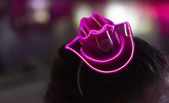 A volunteer wears a neon pink cowboy hat a during a Pink Pony Prom" organized by the Sexual &amp; Gender Minority Youth Resource Center, part of New Avenues for Youth, a nonprofit dedicated to ending youth homelessness, on Friday, May 30, 2025, in Portland, Ore. (AP Photo/Jenny Kane)