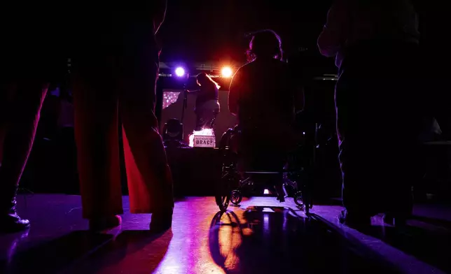 Elliott Auel, second from right, watches drag king Luciano VeriNotti prepare to perform during a "Pink Pony Prom" on Friday, May 30, 2025, in Portland, Ore. (AP Photo/Jenny Kane)