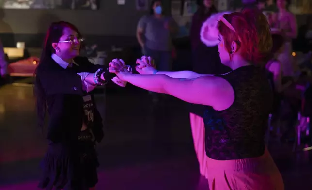 Caspian Brooks and June Arney, left, dance together during a "Pink Pony Prom" on Friday, May 30, 2025, in Portland, Ore. (AP Photo/Jenny Kane)