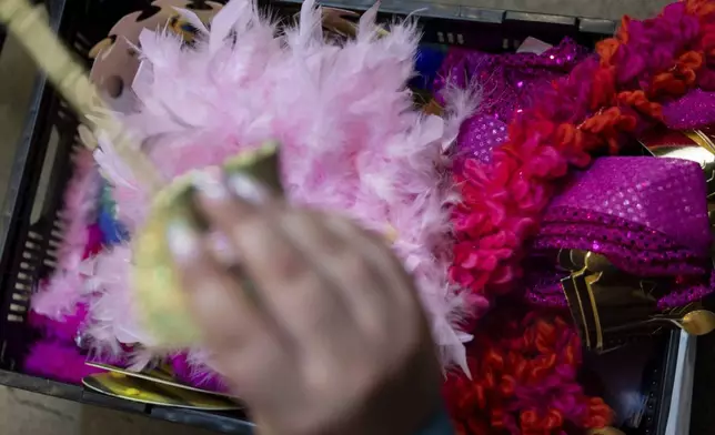 A person takes out a mask from a bin of costume accessories during a "Pink Pony Prom" on Friday, May 30, 2025, in Portland, Ore. (AP Photo/Jenny Kane)