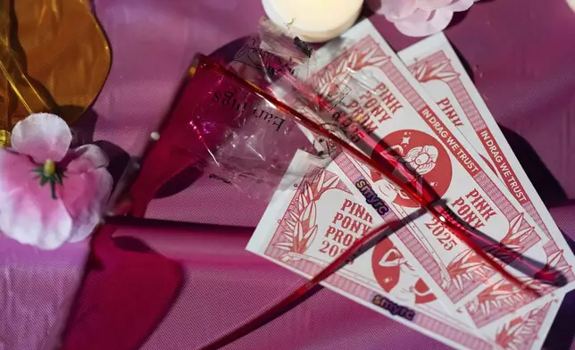 Items rest on a table for attendees during a "Pink Pony Prom" on Friday, May 30, 2025, in Portland, Ore. (AP Photo/Jenny Kane)