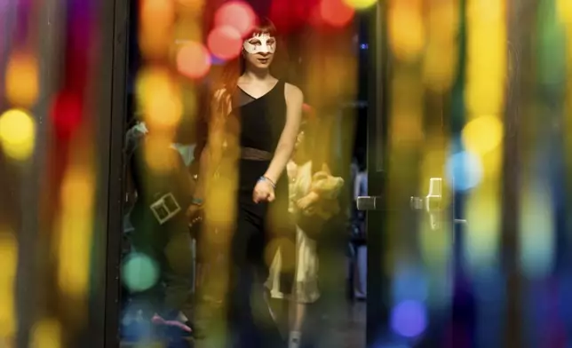 Melody Jenkins is seen through rainbow streamers during a "Pink Pony Prom" organized by the Sexual &amp; Gender Minority Youth Resource Center, part of New Avenues for Youth, a nonprofit dedicated to ending youth homelessness, on Friday, May 30, 2025, in Portland, Ore. (AP Photo/Jenny Kane)