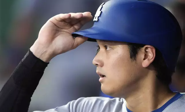 Los Angeles Dodgers' Shohei Ohtani watches from the dugout during the fifth inning of a baseball game against the Kansas City Royals, Friday, June 27, 2025, in Kansas City, Mo. (AP Photo/Charlie Riedel)