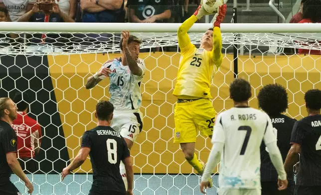 United States goalkeeper Matthew Freese (25) grabs a corner kick after Costa Rica defender Francisco Calvo (15) missed heading it in the second half of a CONCACAF Gold Cup quarterfinals soccer match Sunday, June 29, 2025, in Minneapolis. (Jeff Wheeler/Star Tribune via AP)