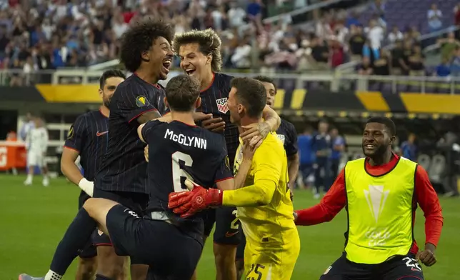 United States goalkeeper Matthew Freese (25) is congratulated after he saved enough Costa Rica penalty kicks for his team to prevail in a CONCACAF Gold Cup quarterfinals soccer match Sunday, June 29, 2025, in Minneapolis. (Jeff Wheeler/Star Tribune via AP)
