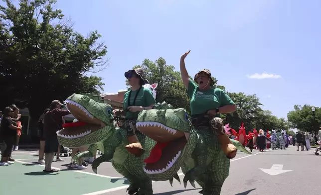 Crowds dressed in inflatable costumes participate in the 'Rhino Rumble Road Race' to celebrate the 30th anniversary of the film 'Jumanji' in downtown Keene, N.H. on Saturday, June 21, 2025. (AP Photo/Leah Willingham)