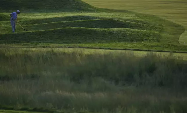 A person uses a rake to maintain the course before the start of the first round of U.S. Open golf tournament at Oakmont Country Club Thursday, June 12, 2025, in Oakmont, Pa. (AP Photo/Seth Wenig)