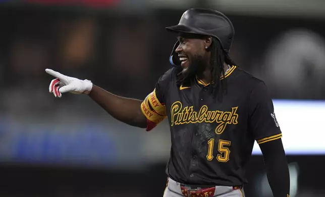 Pittsburgh Pirates' Oneil Cruz jokes with San Diego Padres first baseman Luis Arraez after hitting a single during the seventh inning of a baseball game Saturday, May 31, 2025, in San Diego. (AP Photo/Gregory Bull)