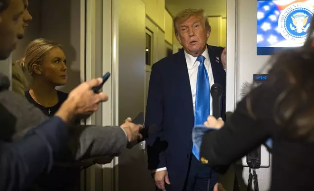 President Donald Trump speaks with reporters as White House press secretary Karoline Leavitt listens while flying aboard Air Force One en route from Calgary, Canada to Joint Base Andrews, Md., late Monday, June 16, 2025. (AP Photo/Mark Schiefelbein)
