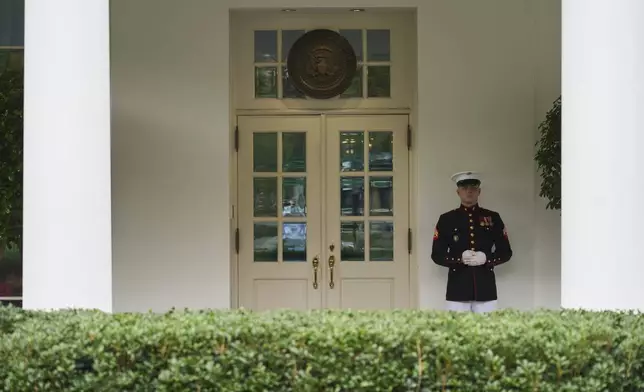 A U.S. Marine stands outside the entrance to the West Wing of the White House as President Donald Trump meets in the Situation Room, Tuesday, June 17, 2025, in Washington. (AP Photo/Evan Vucci)