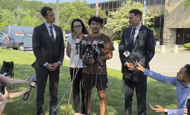 Marcelo Gomes da Silva, 18, center, a Massachusetts high school student who came to the U.S. from Brazil at age 7 and was detained by U.S. Immigration and Customs Enforcement agents Saturday, May 31, 2025, speaks to journalists after being released from detention on bond as Reps. Seth Moulton, D-Mass., right, and Jake Auchincloss, D-Mass., left, listen, Thursday, June 5, 2025, in Burlington, Mass. (AP Photo/Rodrique Ngowi)