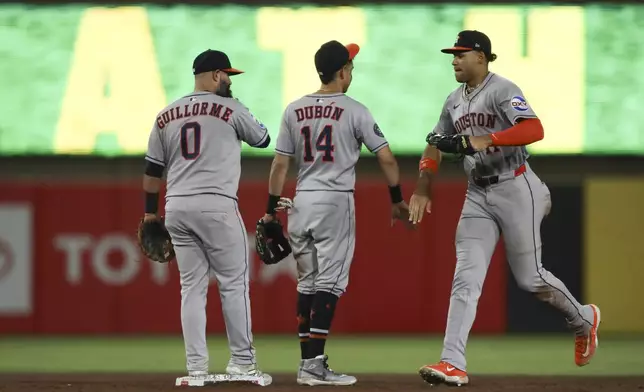 Houston Astros' Cam Smith, right, celebrates with Mauricio Dubón (14) after their win over the Athletics in a baseball game against the Athletics Tuesday, June 17, 2025, in West Sacramento, Calif. (AP Photo/Scott Marshall)