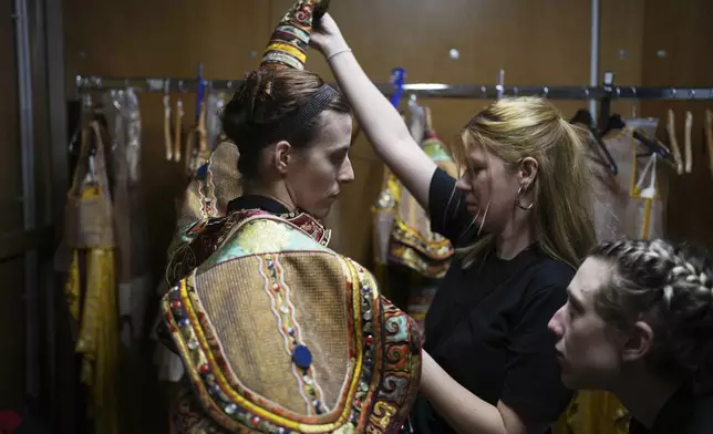 Dancers Anastasia Valsamaki, left, and Antonia Oikonomou, right, prepare ahead of Giacomo Puccini's "Turandot" performance by the Greek National Opera during the 70th Athens Epidaurus Festival at the Odeon of Herodes Atticus in Athens, Greece, Tuesday, June 3, 2025. (AP Photo/Thanassis Stavrakis)