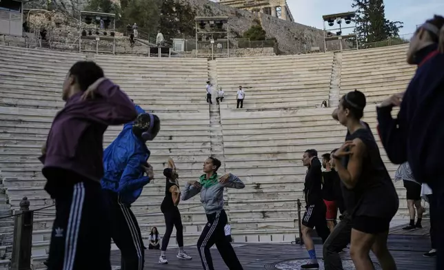 Dancers warm up at the Odeon of Herodes Atticus ahead of the dress rehearsal of Giacomo Puccini's "Turandot" by the Greek National Opera under the ancient Acropolis hill during the 70th Athens Epidaurus Festival in Athens, Greece, Friday, May 30, 2025. (AP Photo/Thanassis Stavrakis)