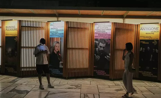 People walk outside the Odeon of Herodes Atticus during Giacomo Puccini's "Turandot" performance by the Greek National Opera part of the 70th Athens Epidaurus Festival in Athens, Greece, Tuesday, June 3, 2025. (AP Photo/Thanassis Stavrakis)