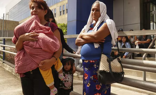 Relatives of Alejandro Henriquez and Jose Angel Perez wait outside the courts during their hearing in Santa Tecla, El Salvador, Friday, May 30, 2025. The National Civil Police arrested them for protesting near the presidnetial residence. (AP Photo/Salvador Melendez)