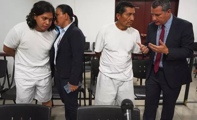 Alejandro Henriquez, left, and Jose Angel Perez, second from right, speak with their lawyers prior to their first court hearing in Santa Tecla, El Salvador, Friday, May 30, 2025. The National Civil Police arrested them for protesting near the presidential residence. (AP Photo/Salvador Melendez)