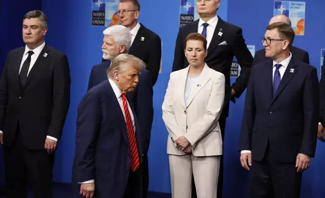 President Donald Trump, center left, walks by Denmark's Prime Minister Mette Frederiksen, center front, prior to a group photo of NATO heads of state and government at the NATO summit in The Hague, Netherlands, Wednesday, June 25, 2025. (AP Photo/Geert Vanden Wijngaert)