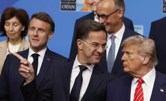 President Donald Trump, right, speaks with NATO Secretary General Mark Rutte during a group photo of NATO heads of state and government at the NATO summit in The Hague, Netherlands, Wednesday, June 25, 2025. (AP Photo/Geert Vanden Wijngaert)