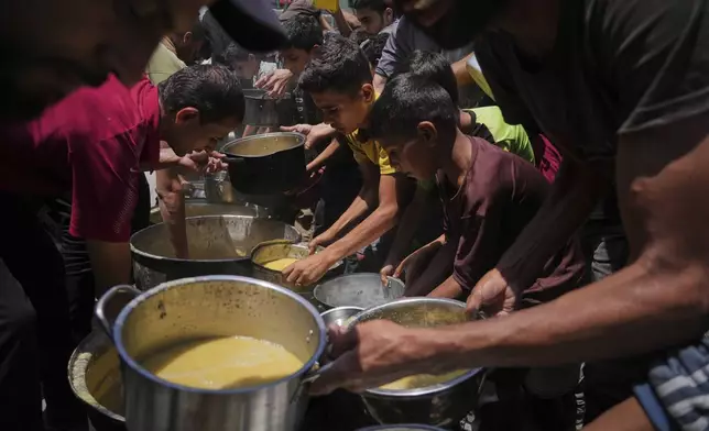 Palestinians receive donated food at a community kitchen in Gaza City, Tuesday, June 10, 2025. (AP Photo/Jehad Alshrafi)