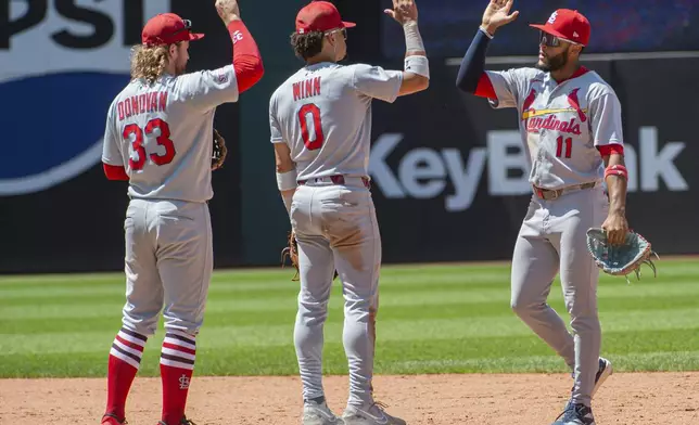 St. Louis Cardinals' Masyn Winn (0) and Brendan Donovan (33) greet Victor Scott II (11) at the end of a baseball game against the Cleveland Guardians, Sunday, June 29, 2025, in Cleveland. (AP Photo/Phil Long)