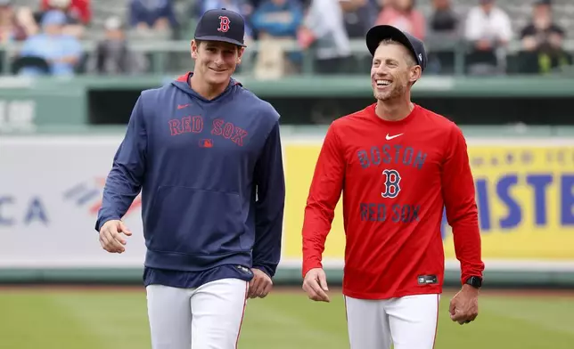 Boston Red Sox outfielder Roman Anthony, left, smiles as he walks with third base coach Kyle Hudson before making his first major league start in a baseball game against the Tampa Bay Rays at Fenway Park, Monday, June 9, 2025, in Boston. (AP Photo/Mary Schwalm)