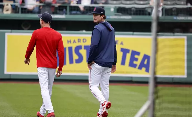 Boston Red Sox outfielder Roman Anthony, right, looks over his shoulder as he walks out on the field with third base coach Kyle Hudson before making his first major league start in a baseball game against the Tampa Bay Rays at Fenway Park, Monday, June 9, 2025, in Boston. (AP Photo/Mary Schwalm)