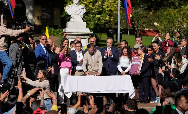 Colombia's President Gustavo Petro signs a labor reform bill into law in Bogota, Colombia, Wednesday, June 25, 2025. (AP Photo/Fernando Vergara)