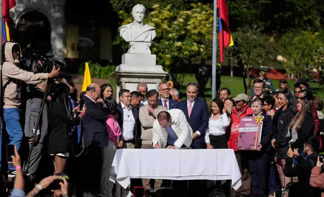 Colombia's Labor Minister Antonio Sanguino signs a labor reform bill into law in Bogota, Colombia, Wednesday, June 25, 2025. (AP Photo/Fernando Vergara)