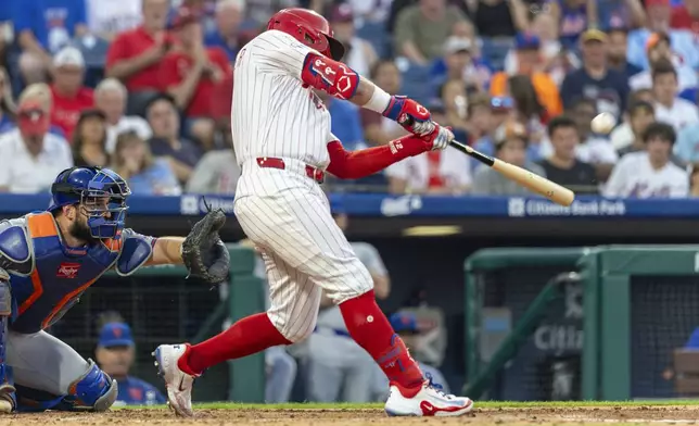 Philadelphia Phillies' Kyle Schwarber hits a solo home run during the fourth inning of a baseball game against the New York Mets, Sunday, June 22, 2025, in Philadelphia. (AP Photo/Laurence Kesterson)