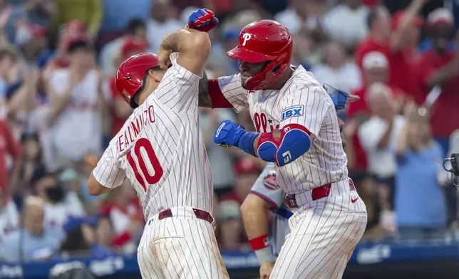 Philadelphia Phillies' Edmundo Sosa, right, celebrates his three-run home run with J.T. Realmuto (10) during the fourth inning of a baseball game against the New York Mets, Sunday, June 22, 2025, in Philadelphia. (AP Photo/Laurence Kesterson)