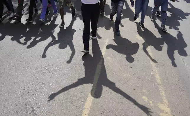 Protesters raise their hands up as police fire teargas at them during a demonstration on the one-year anniversary of deadly anti-tax demonstrations in downtown Nairobi, Kenya, Wednesday, June 25, 2025. (AP Photo/Brian Inganga)
