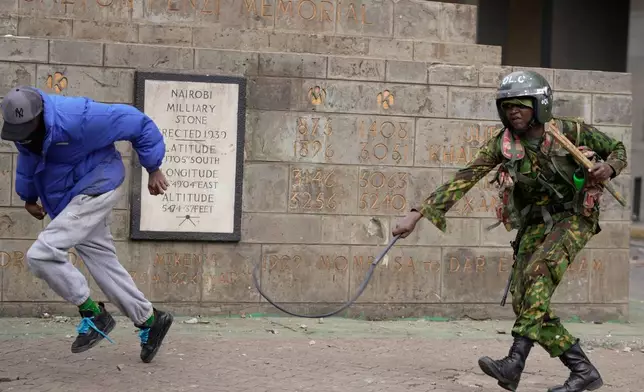 A Kenyan police whips a protester during a demonstration in downtown Nairobi, Kenya, Wednesday, June 25, 2025. (AP Photo/Brian Inganga)