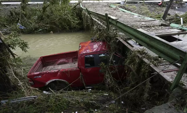 A vehicle sits in flood debris, Monday, June 16, 2025, in Valley Grove, W.Va. (AP Photo/Carolyn Kaster)