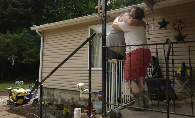 Norma and John Black hug outside their flood-damaged home, Monday, June 16, 2025, in Valley Grove, W.Va. (AP Photo/Carolyn Kaster)