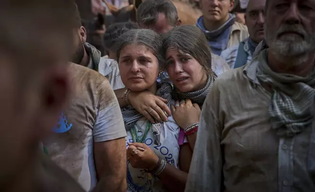 Pilgrims walk through dusty terrain near Aznalcazar, Spain, during the annual Catholic pilgrimage to the shrine of the Virgin of El Rocio, that draws hundreds of thousands of faithful, Friday, June 6, 2025.(AP Photo/Emilio Morenatti)