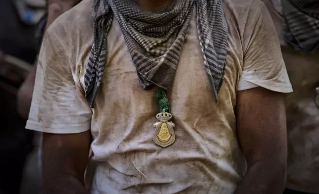 Pilgrims walk through dusty terrain near Aznalcázar, Spain, during the annual Catholic pilgrimage to the shrine of the Virgin of El Rocio, Friday, June 6, 2025. (AP Photo/Emilio Morenatti)