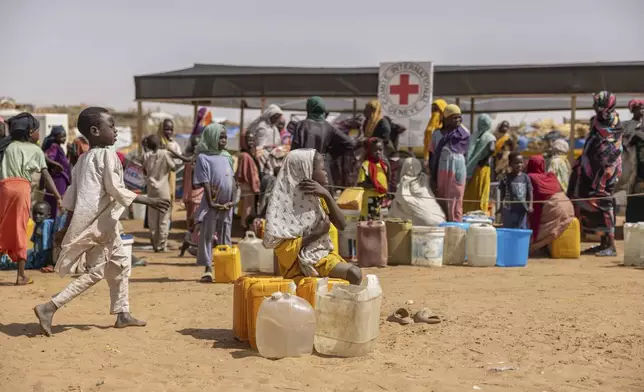 Refugees queue at a Red Cross water point in the Adre, Chad, transit camp, Tuesday, May 6, 2025. (AP Photo/Caitlin Kelly)