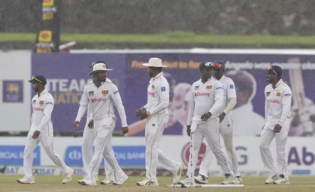 Sri Lanka's team members walk off the field as it rains during the fifth day of the first cricket test match between Sri Lanka and Bangladesh in Galle, Sri Lanka, Saturday, June 21, 2025. (AP Photo/Eranga Jayawardena)