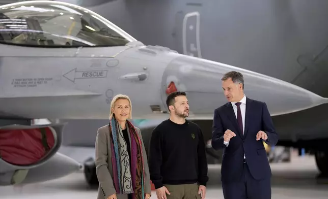 FILE - Belgium's Prime Minister Alexander De Croo, right, and Belgium's Defense Minister Ludivine Dedonder, left, pose with Ukraine's President Volodymyr Zelenskyy in front of an F-16 at Melsbroek military airport in Brussels, on May 28, 2024. (AP Photo/Virginia Mayo, File)