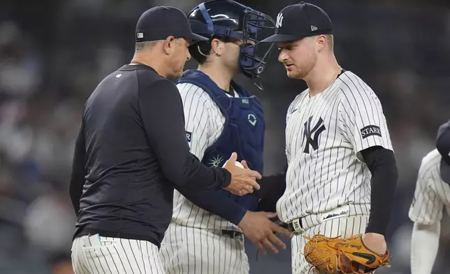 New York Yankees pitcher Clarke Schmidt hands the ball to manager Aaron Boone as he leaves during the sixth inning of a baseball game, Wednesday, June 4, 2025, in New York. (AP Photo/Frank Franklin II)