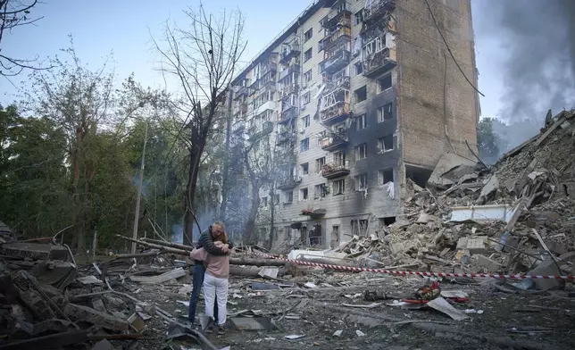 Residents react after a Russian missile hit a multi-storey apartment during Russia's combined missile and drone air attack in Kyiv, Ukraine, Tuesday, June 17, 2025. (AP Photo/Efrem Lukatsky)