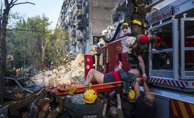 Rescue workers evacuate an injured man from a multi-storey residential house destroyed by a Russian strike in Kyiv, Ukraine, on Tuesday, June 17, 2025. (AP Photo/Evgeniy Maloletka)