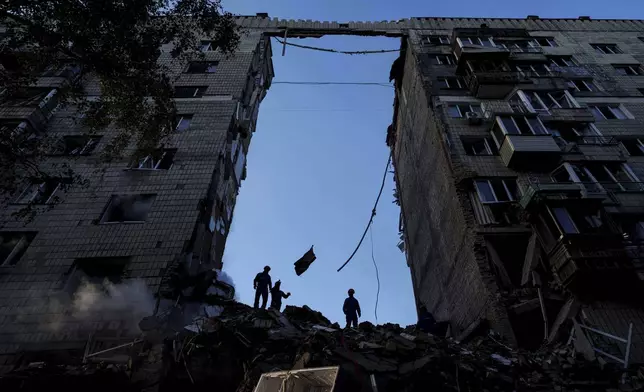 Rescue workers clear the rubble of a multi-storey residential house destroyed by a Russian strike in Kyiv, Ukraine, on Tuesday, June 17, 2025. (AP Photo/Evgeniy Maloletka)