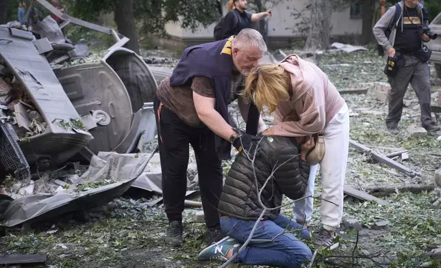 Residents react after a Russian missile hit a multi-storey apartment during Russia's massive missile and drone air attack in Kyiv, Ukraine, Tuesday, June 17, 2025. (AP Photo/Efrem Lukatsky)