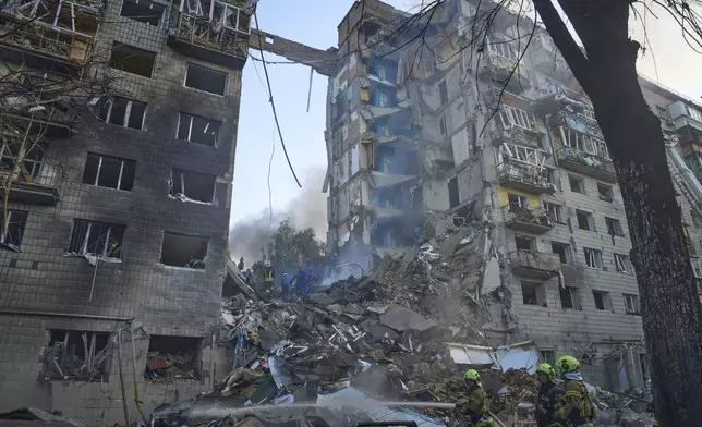 Firefighters put out the fire after a Russian missile hit a residential building during Russia's combined missile and drone air attack in Kyiv, Ukraine, Tuesday, June 17, 2025. (AP Photo/Efrem Lukatsky)